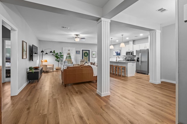 319 Key Lime Pl, Crestview, FL 32536 - living room with ornate columns, light wood finished floors, a ceiling fan, baseboards, and recessed lighting