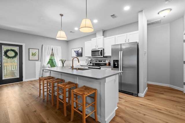 319 Key Lime Pl, Crestview, FL 32536 - kitchen with stainless steel appliances, a sink, light wood-style floors, a breakfast bar, and a kitchen island with sink