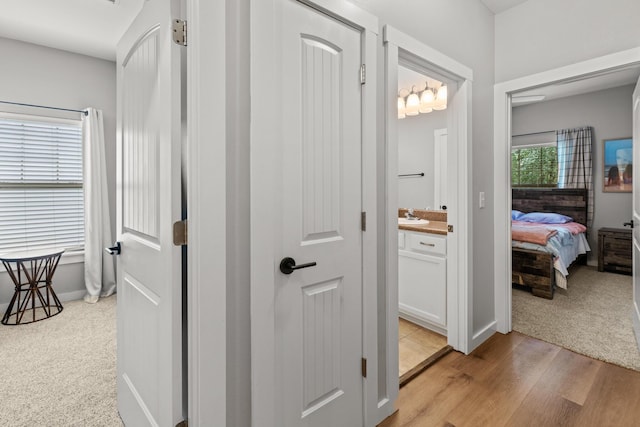 319 Key Lime Pl, Crestview, FL 32536 - hallway featuring a sink, light carpet, baseboards, and light wood-style flooring