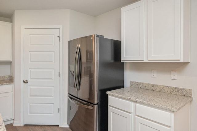 4652 Honor Guard Way, Crestview, FL 32539 - kitchen featuring stainless steel fridge with ice dispenser, white cabinets, wood finished floors, and light stone countertops