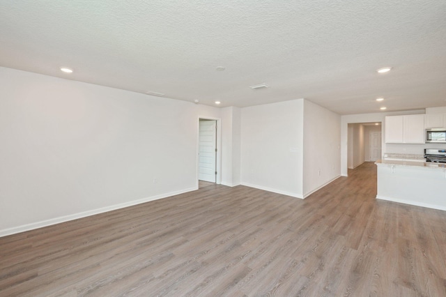 4652 Honor Guard Way, Crestview, FL 32539 - unfurnished living room with light wood-style flooring, recessed lighting, and a textured ceiling