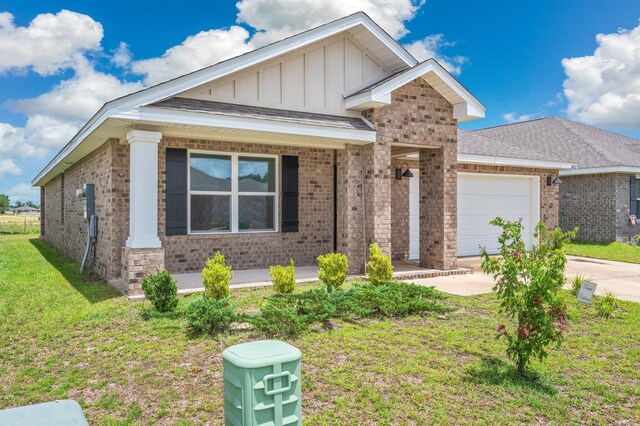 4652 Honor Guard Way, Crestview, FL 32539 - view of front of property with board and batten siding, brick siding, an attached garage, and a front lawn