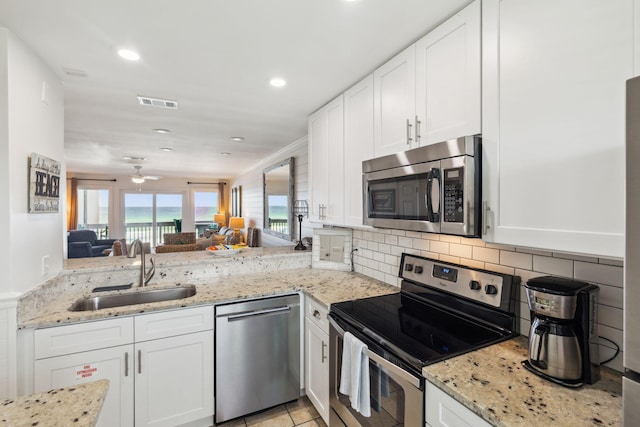 23011 Front Beach Rd Unit E-20, Panama City Beach, FL 32413 - kitchen with stainless steel appliances, a sink, white cabinets, light stone countertops, and recessed lighting