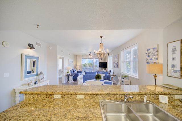 112 Seascape Blvd Unit 210, Miramar Beach, FL 32550 - kitchen with a chandelier, pendant lighting, light stone counters, and open floor plan