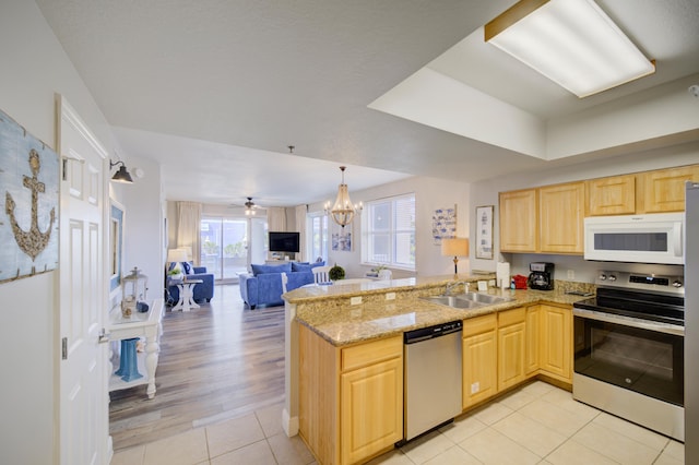 112 Seascape Blvd Unit 210, Miramar Beach, FL 32550 - kitchen featuring stainless steel appliances, light brown cabinets, a peninsula, a chandelier, and open floor plan