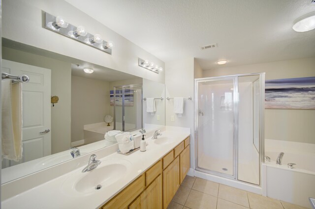 112 Seascape Blvd Unit 210, Miramar Beach, FL 32550 - bathroom featuring a stall shower, a bath, double vanity, tile patterned floors, and a textured ceiling