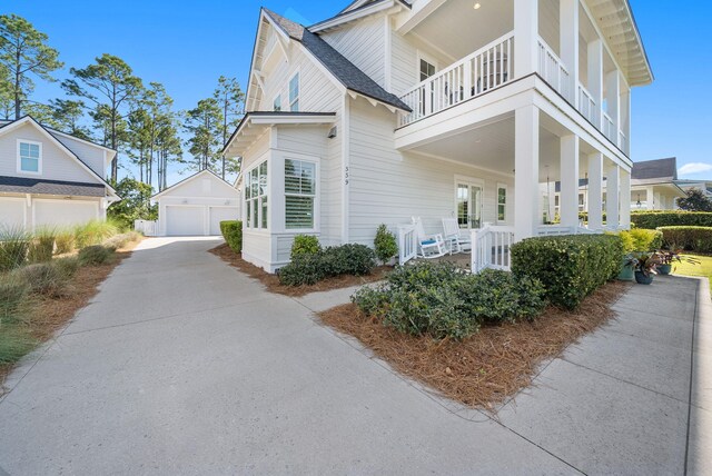 339 Pathways Dr, Inlet Beach, FL 32461 - view of property exterior featuring a balcony, an outbuilding, a detached garage, a porch, and roof with shingles