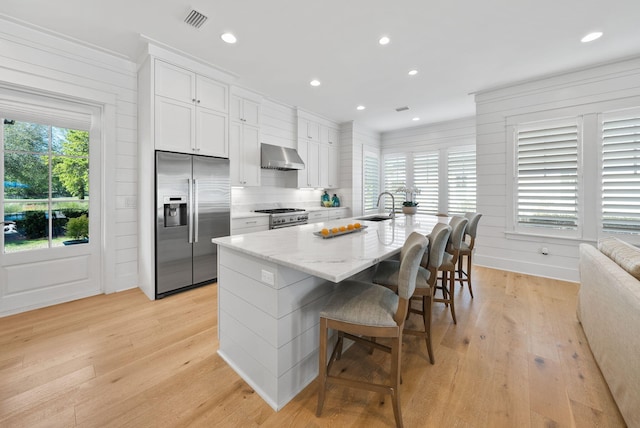 339 Pathways Dr, Inlet Beach, FL 32461 - kitchen with stainless steel appliances, a sink, exhaust hood, a kitchen breakfast bar, and light wood-style flooring