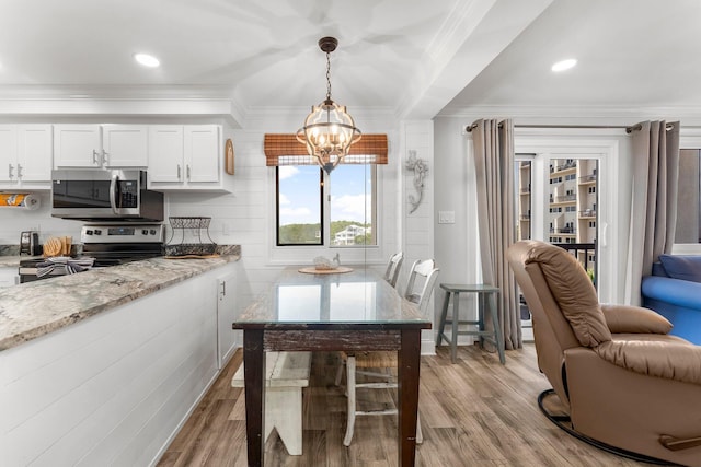 23223 Front Beach Rd # 335, Panama City Beach, FL 32413 - kitchen featuring appliances with stainless steel finishes, a chandelier, open floor plan, light wood-style flooring, and white cabinets