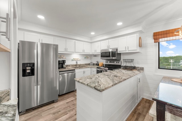 23223 Front Beach Rd # 335, Panama City Beach, FL 32413 - kitchen featuring appliances with stainless steel finishes, a sink, a peninsula, white cabinetry, and ornamental molding