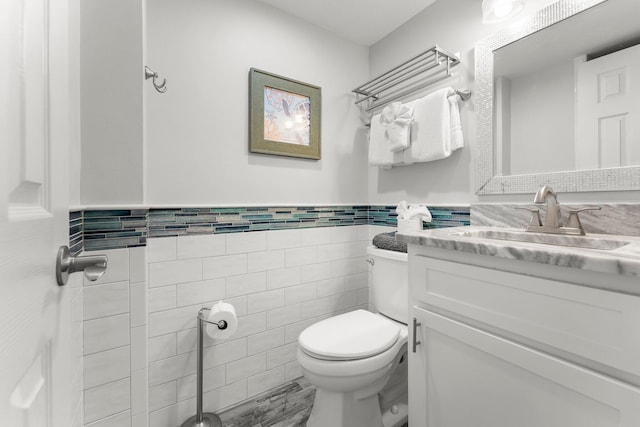 23223 Front Beach Rd # 335, Panama City Beach, FL 32413 - bathroom featuring tile walls, toilet, vanity, and a wainscoted wall