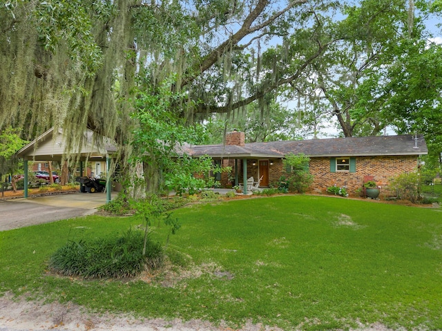 619 Pitts Bayshore Dr, Freeport, FL 32439 - ranch-style home with a chimney, driveway, a detached carport, brick siding, and a front yard