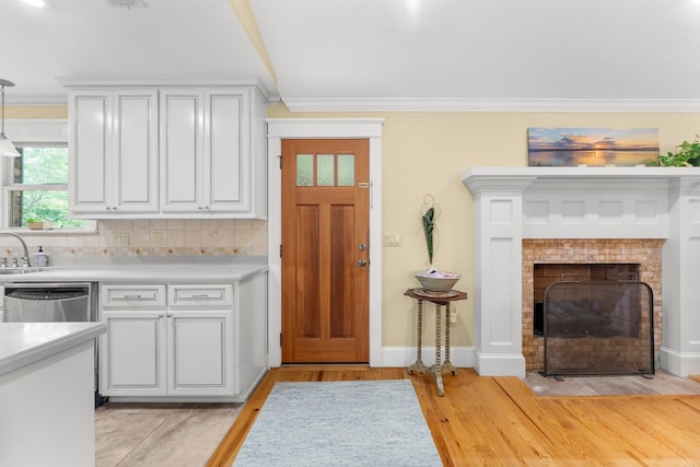 619 Pitts Bayshore Dr, Freeport, FL 32439 - kitchen with dishwasher, crown molding, light countertops, white cabinetry, and light wood-type flooring
