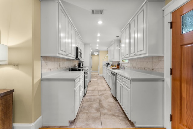 619 Pitts Bayshore Dr, Freeport, FL 32439 - kitchen with appliances with stainless steel finishes, light countertops, backsplash, light tile patterned floors, and recessed lighting