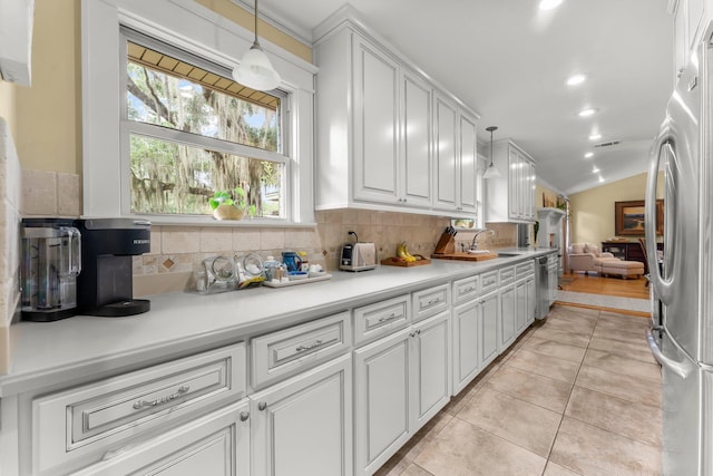 619 Pitts Bayshore Dr, Freeport, FL 32439 - kitchen with backsplash, white cabinetry, light countertops, light tile patterned floors, and pendant lighting