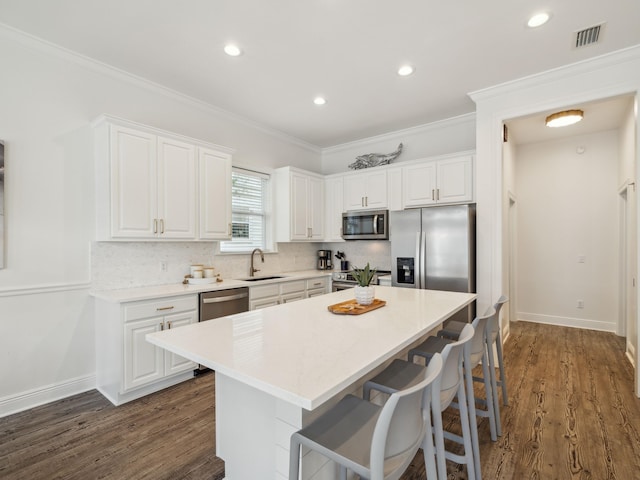 221 Seacrest Beach Blvd E, Seacrest, FL 32461 - kitchen with stainless steel appliances, a breakfast bar, a center island, white cabinetry, and backsplash