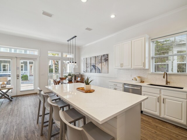 221 Seacrest Beach Blvd E, Seacrest, FL 32461 - kitchen with ornamental molding, white cabinetry, a center island, a kitchen breakfast bar, and dark wood finished floors