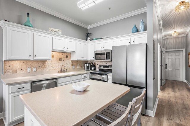 231 Somerset Bridge Rd Unit 2307, Santa Rosa Beach, FL 32459 - kitchen with appliances with stainless steel finishes, a sink, white cabinets, crown molding, and backsplash