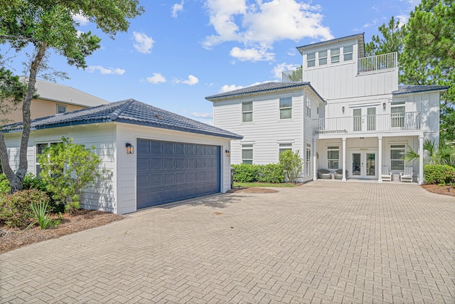 46 N Cypress Breeze Blvd, Santa Rosa Beach, FL 32459 - view of front of property with french doors, a balcony, board and batten siding, decorative driveway, and an outdoor structure