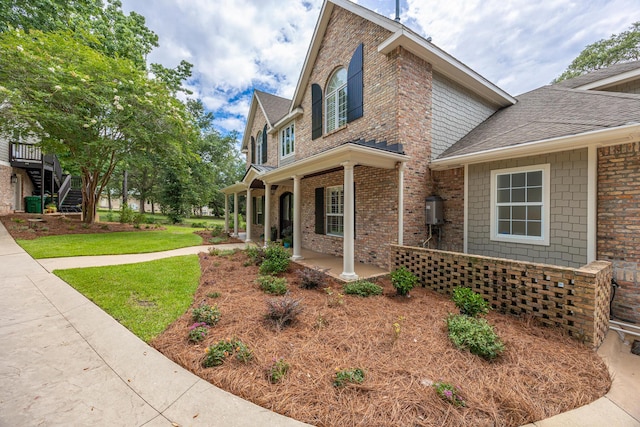 17 Poquito Rd, Shalimar, FL 32579 - view of home's exterior with covered porch, brick siding, a shingled roof, and a lawn