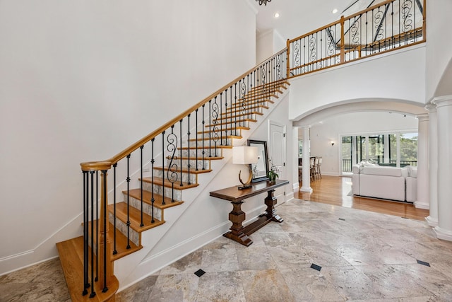 17 Poquito Rd, Shalimar, FL 32579 - stairs featuring ornate columns, arched walkways, stone tile flooring, and a high ceiling