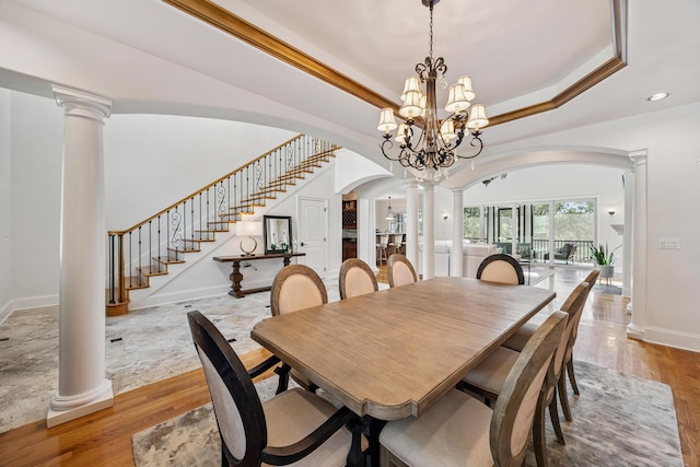 17 Poquito Rd, Shalimar, FL 32579 - dining room featuring arched walkways, decorative columns, light wood-type flooring, stairs, and a raised ceiling