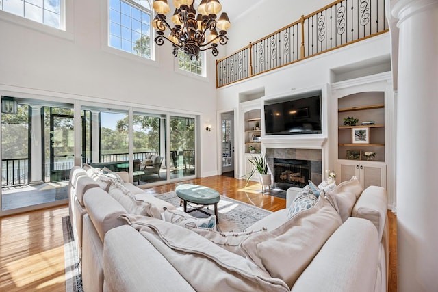 17 Poquito Rd, Shalimar, FL 32579 - living room with a towering ceiling, wood finished floors, a chandelier, a tile fireplace, and built in shelves