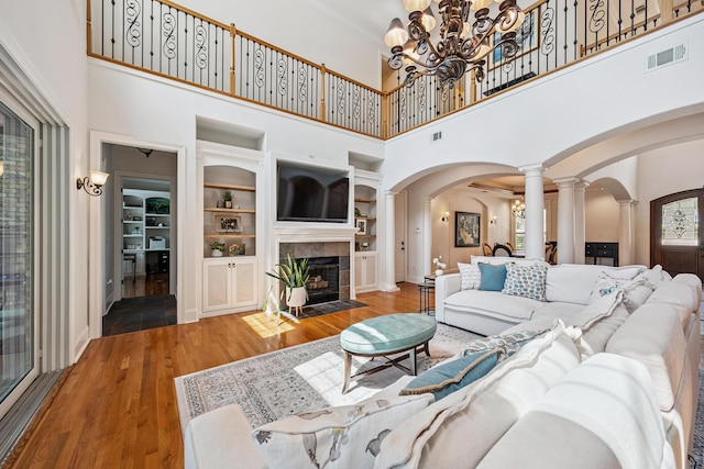 17 Poquito Rd, Shalimar, FL 32579 - living area with ornate columns, arched walkways, wood finished floors, built in shelves, and a fireplace