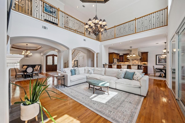 17 Poquito Rd, Shalimar, FL 32579 - living area with arched walkways, ornate columns, a chandelier, hardwood / wood-style flooring, and ornamental molding