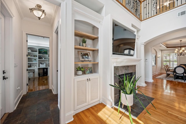 17 Poquito Rd, Shalimar, FL 32579 - hallway with arched walkways, crown molding, built in features, a chandelier, and wood finished floors