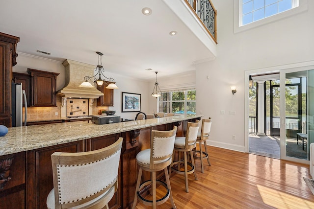 17 Poquito Rd, Shalimar, FL 32579 - kitchen featuring custom range hood, freestanding refrigerator, backsplash, light wood-style floors, and light stone countertops