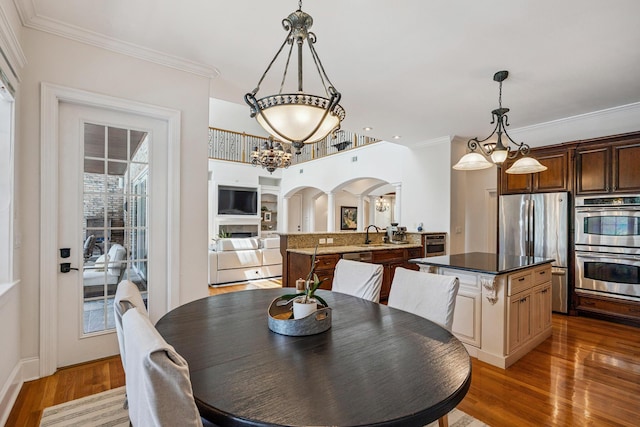 17 Poquito Rd, Shalimar, FL 32579 - dining area featuring arched walkways, light wood-style flooring, ornamental molding, and a chandelier