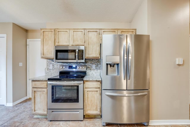 121 Trenton Ave, Crestview, FL 32539 - kitchen featuring appliances with stainless steel finishes, light brown cabinets, light stone countertops, and backsplash