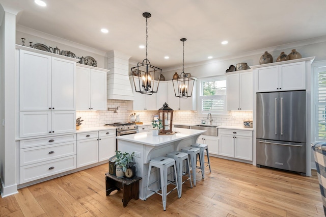 1502 Coriander Ln, Niceville, FL 32578 - kitchen featuring high quality fridge, premium range hood, white cabinets, ornamental molding, and light countertops