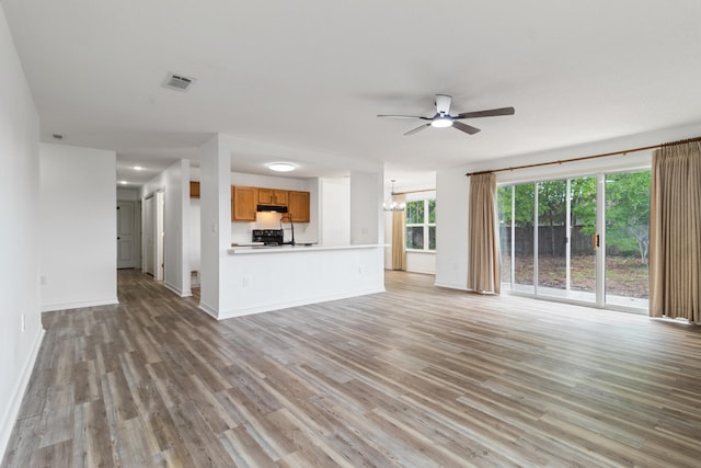 51 Yearling Ct, Defuniak Springs, FL 32433 - unfurnished living room with a ceiling fan, light wood-type flooring, and a chandelier