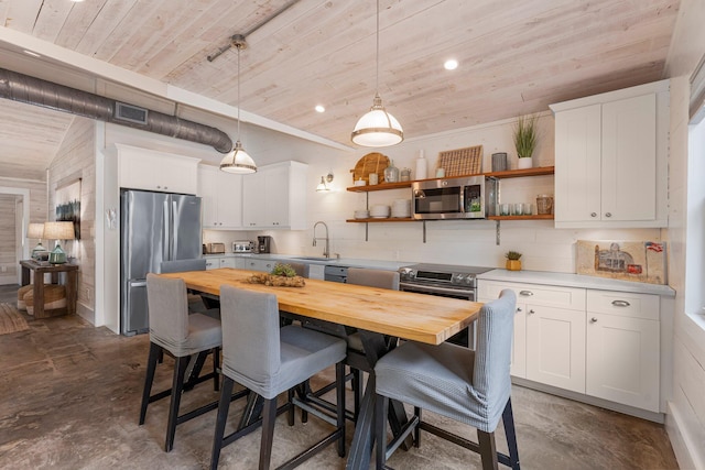 81 Canal St, Santa Rosa Beach, FL 32459 - kitchen featuring butcher block countertops, stainless steel appliances, wooden ceiling, concrete flooring, and a kitchen bar
