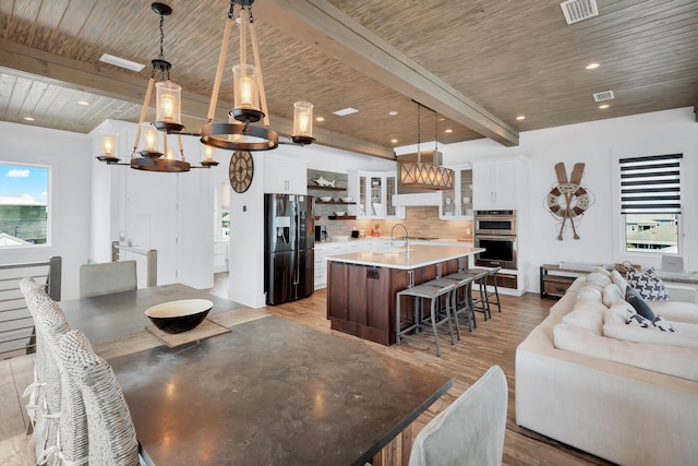 64 S Emerald Cove Ln, Inlet Beach, FL 32461 - kitchen featuring fridge with ice dispenser, a chandelier, backsplash, a kitchen breakfast bar, and light wood-style floors