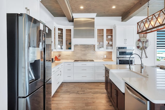 64 S Emerald Cove Ln, Inlet Beach, FL 32461 - kitchen featuring appliances with stainless steel finishes, wall chimney exhaust hood, beamed ceiling, light wood-style flooring, and light countertops