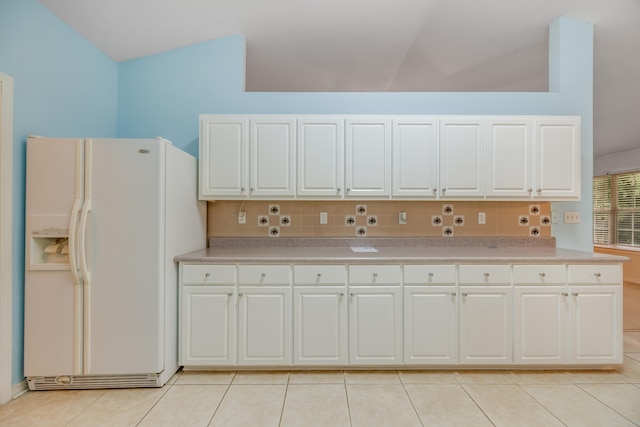 2124 Hagood Loop, Crestview, FL 32536 - kitchen with white fridge with ice dispenser, vaulted ceiling, tasteful backsplash, light tile patterned flooring, and light countertops