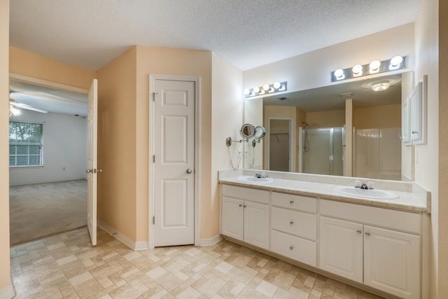 2124 Hagood Loop, Crestview, FL 32536 - bathroom featuring double vanity, a stall shower, and a textured ceiling