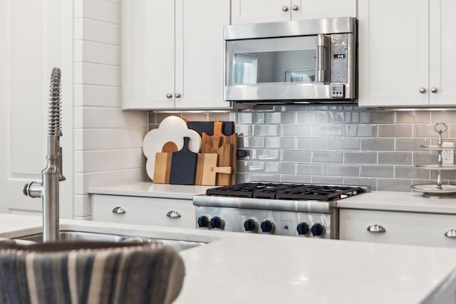 360 Jack Knife Dr, Inlet Beach, FL 32461 - kitchen with stainless steel microwave, light countertops, stove, white cabinets, and tasteful backsplash