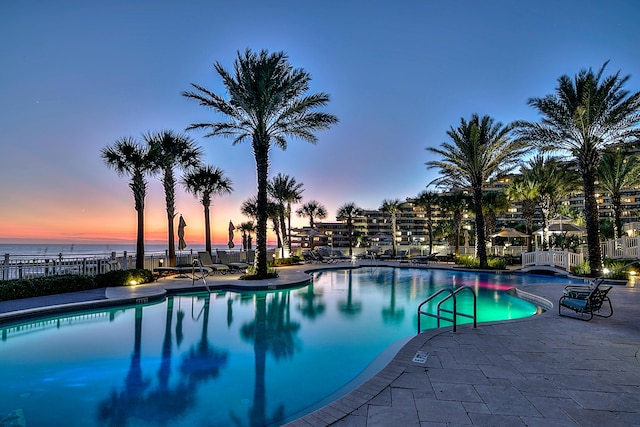 219 Scenic Gulf Dr Unit 930, Miramar Beach, FL 32550 - pool at dusk with a community pool, a patio, and a water view