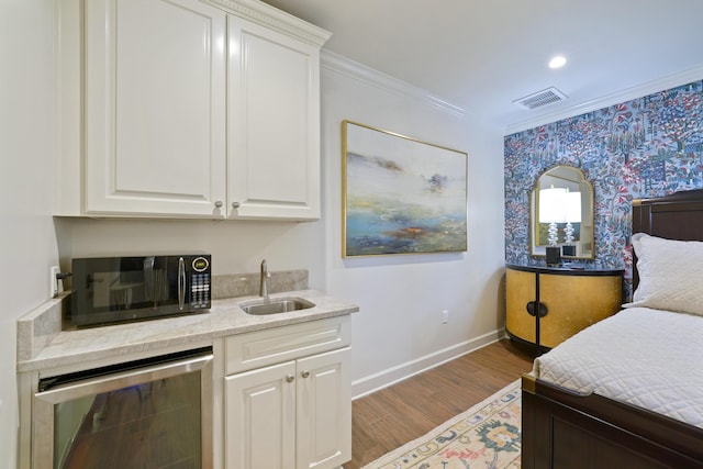 219 Scenic Gulf Dr Unit 930, Miramar Beach, FL 32550 - bedroom with wine cooler, wood finished floors, crown molding, and wallpapered walls