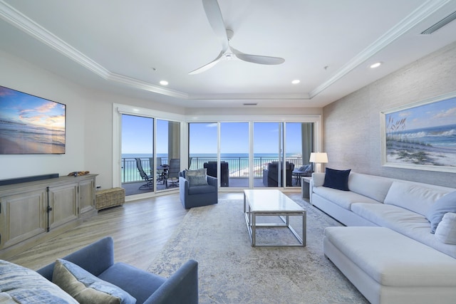 219 Scenic Gulf Dr Unit 930, Miramar Beach, FL 32550 - living area with a tray ceiling, light wood-style flooring, a water view, a ceiling fan, and crown molding
