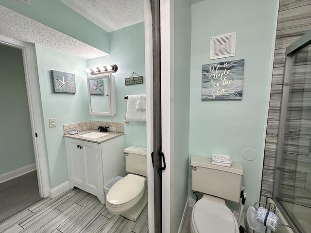 8743 Thomas Dr Unit 924, Panama City Beach, FL 32408 - bathroom with vanity, a textured ceiling, wood finish floors, and a shower