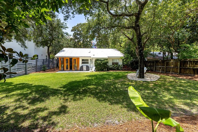 41 E Grove Ave, Santa Rosa Beach, FL 32459 - back of property with a fenced backyard, a metal roof, and a patio area