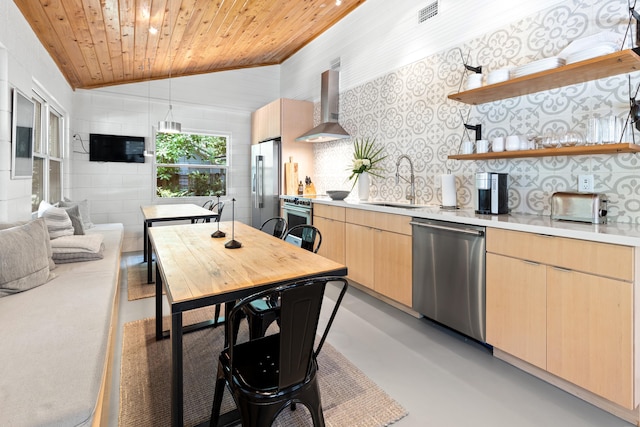 41 E Grove Ave, Santa Rosa Beach, FL 32459 - kitchen featuring stainless steel appliances, wall chimney exhaust hood, light brown cabinets, concrete floors, and light countertops