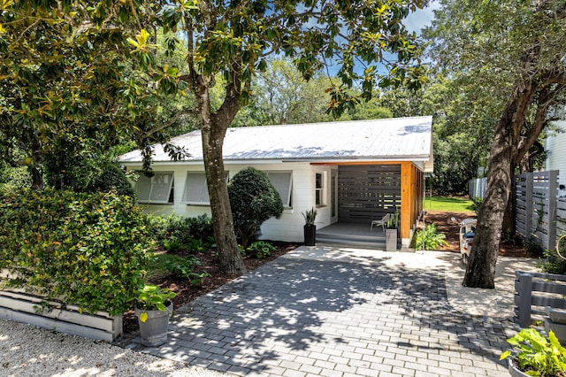 41 E Grove Ave, Santa Rosa Beach, FL 32459 - view of front of home featuring concrete block siding, driveway, and a metal roof