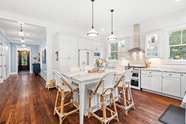 117 W Okeechobee, Santa Rosa Beach, FL 32459 - kitchen featuring double oven range, wall chimney exhaust hood, a breakfast bar, white cabinets, and dark wood-style flooring