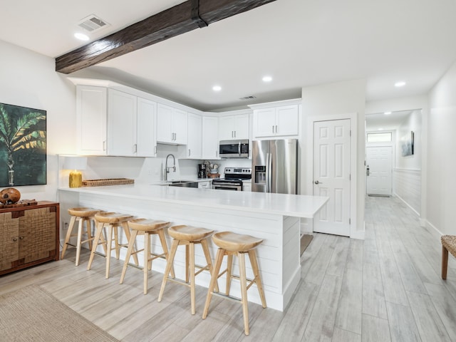 3604 E County Highway 30a Unit D5, Santa Rosa Beach, FL 32459 - kitchen featuring stainless steel appliances, a peninsula, light countertops, light wood-style floors, and beamed ceiling